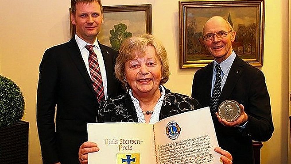 Der Präsident des Paderborner Lions-Club, Michael Plöger (l.), und der Vorsitzende des Niels-Stenses-Preis-Kommitee, Dr. Erich Schmidtmann, überreichten Maria Lis, Vorsitzende der Deutsch-Französischen-Gesellschaft, eine entsprechende Urkunde und Plakette